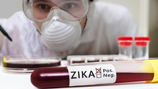 Test tube with blood for ZIKA virus test in front of researcher